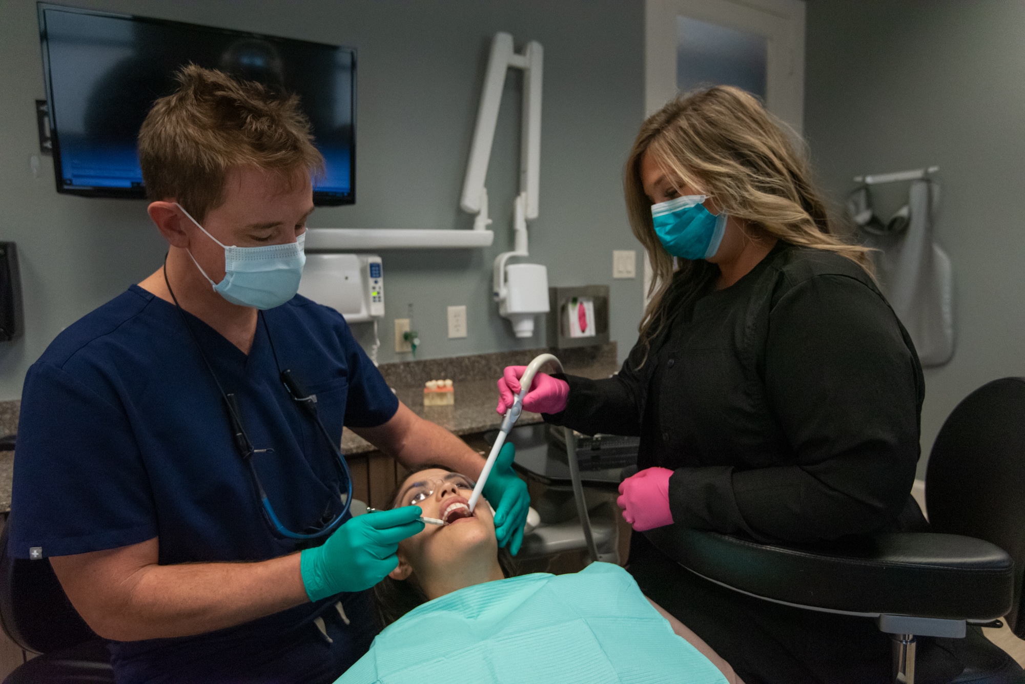 Dentist in Benbrook with his assistant treating a patient using advanced dental technology.